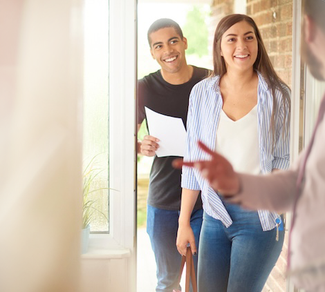 Showing agent opening the door to potential home buyers