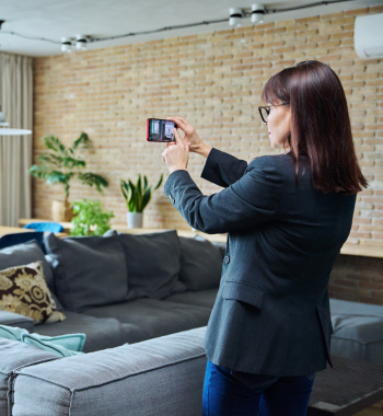 Female real estate agent taking photos with her phone of a property